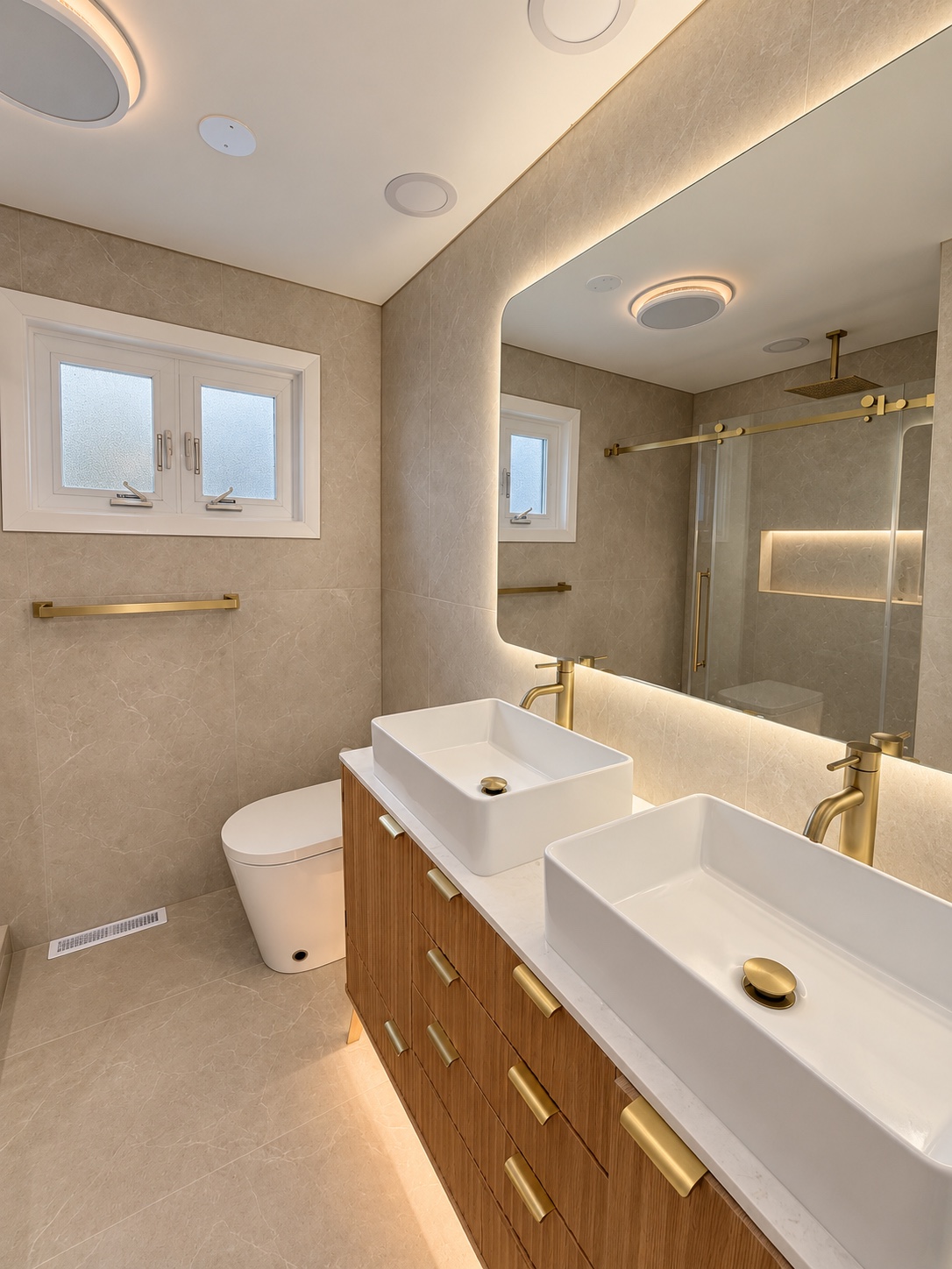 Double vanity and layered lighting — Warm Stone Bath Retreat by Alpha Handyworks